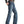 Load image into Gallery viewer, side view of Man wearing a dark grey button up tucked into faded wash blue jeans with a gold belt buckle and cowboy boots
