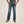 Load image into Gallery viewer, front view of person wearing distressed denim dark blue jeans with brown belt, grey shirt, and tan boots
