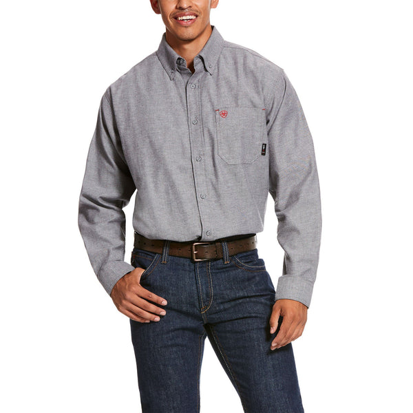 tan man wearing a grey twill button up tucked in to blue jeans