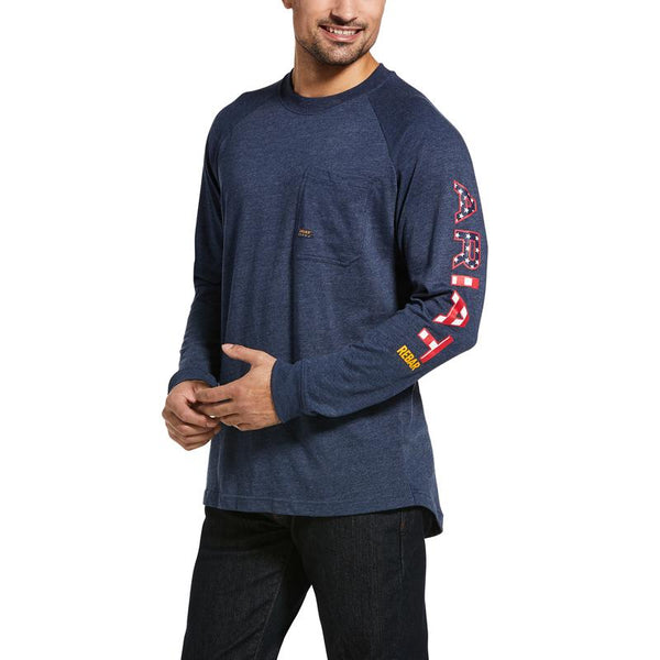 man wearing heather blue long sleeve shirt with Ariat written on the sleeve in an American flag patter