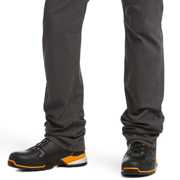 lower leg view of man wearing grey work pants and black and orange work shoes