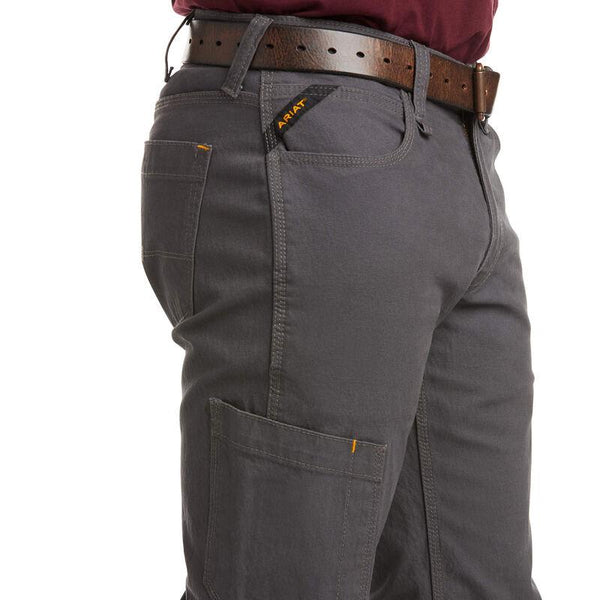 front pocket view of man wearing grey work pants and black and orange work shoes