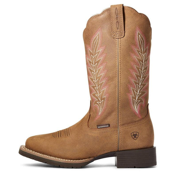side view of Brown cowgirl boot with a pink and white feather embroidery 