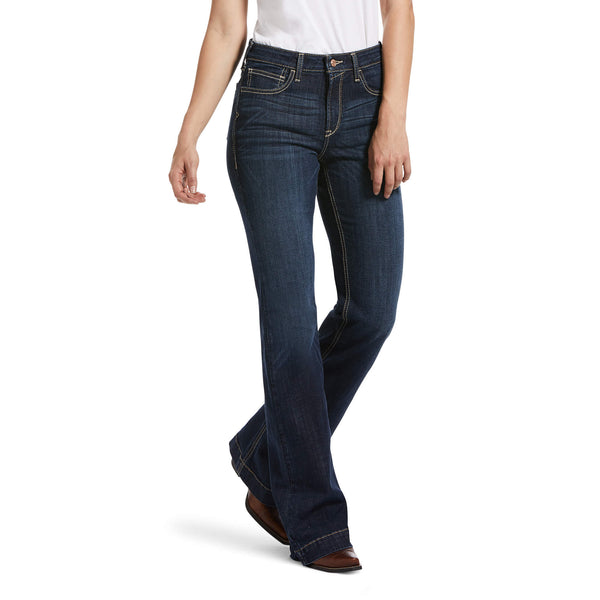 woman wearing dark blue jeans and white shirt with hands at her sides casually