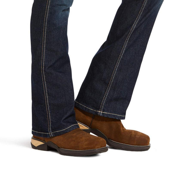 lower leg view of dark blue jeans and brown work boots on woman