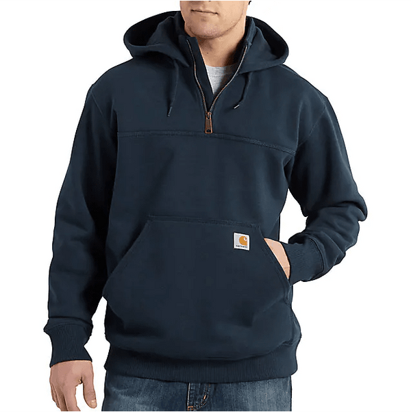 man wearing navy quarter zip hoodie with one hand in pocket