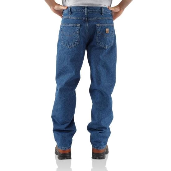 back view of man wearing relaxed dark jeans and boots with hands on his hips
