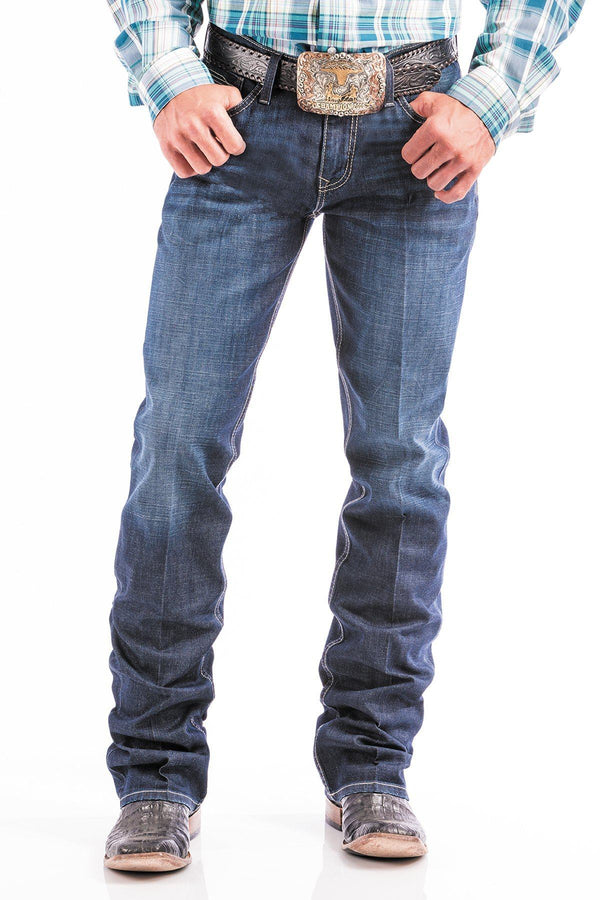 man wearing blue jeans with large silver belt buckle and boots