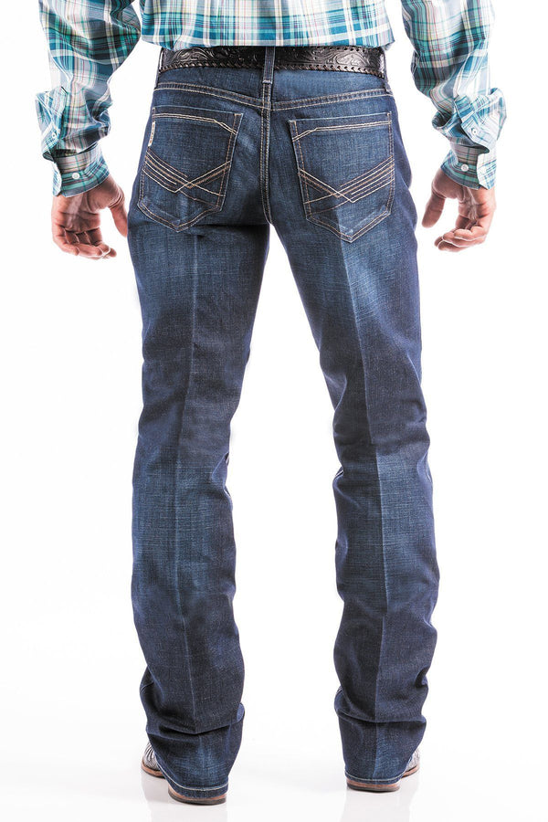 rear view of man wearing blue jeans with large silver belt buckle and boots