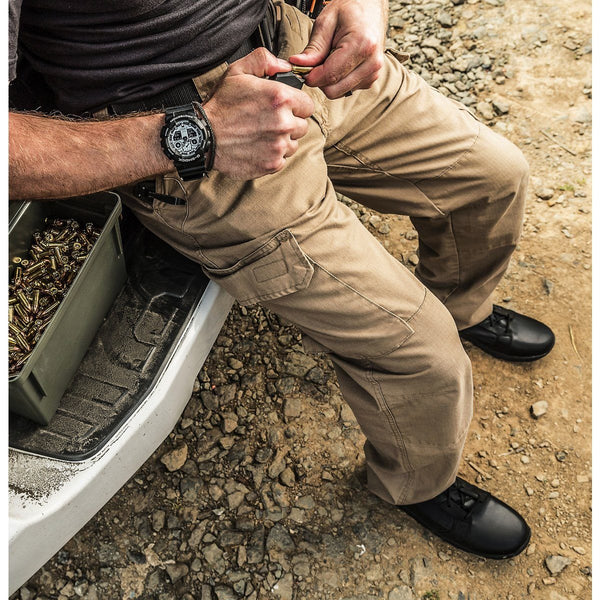 man loading ammo into gun while wearing brown pants and black boots