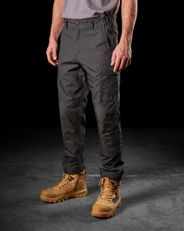 man wearing black light weight work pants, grey tucked shirt, and tan boots