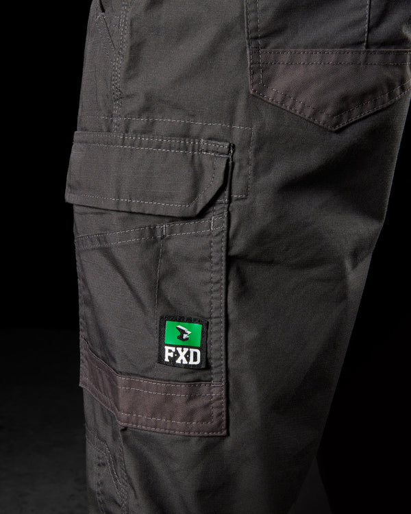 close view of black light weight work pants and FXD logo on side pocket with flap and grey stitching