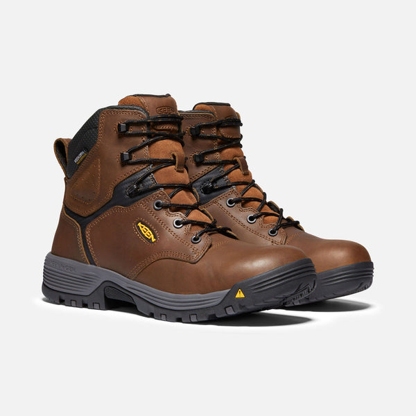 two tan hightop boots with black laces and eyelets, grey and black sole