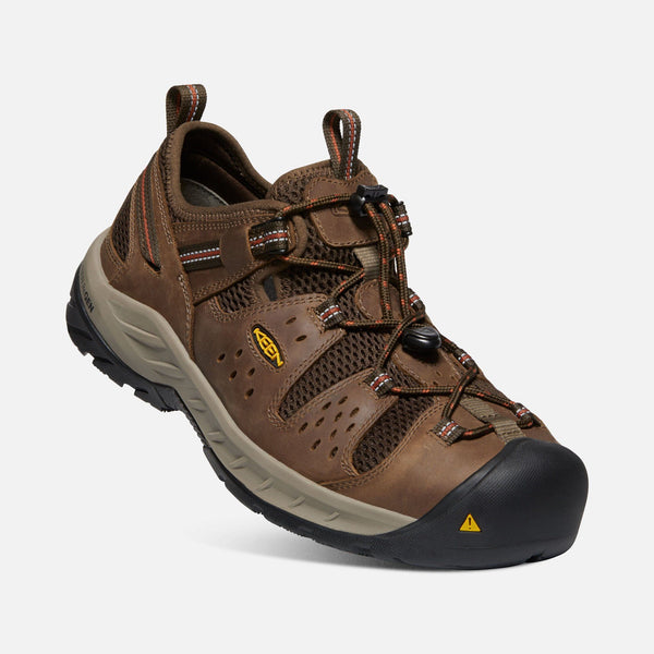 angled view of sneaker style brown outdoor shoes with black toe guard and brown laces