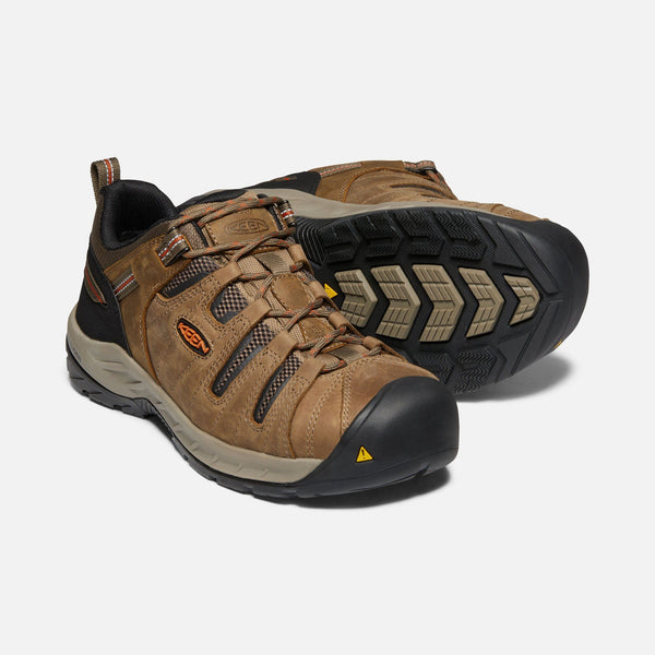 two light brown outdoor shoes with black toe guard and brown laces