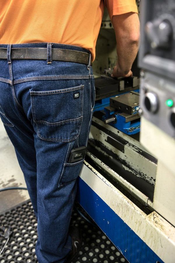 man working and wearing navy blue denim boot cut jeans with leg pockets