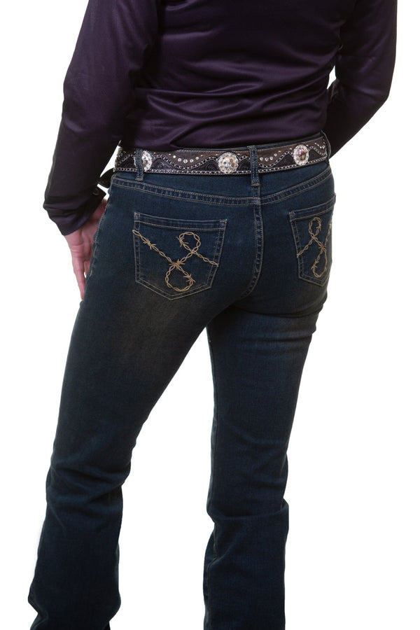back of woman wearing dark blue jeans with barbwire embroidered on back pockets and black long sleeve shirt and studded belt.