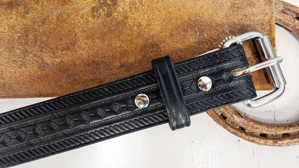 black leather belt with stamped design on metal stand