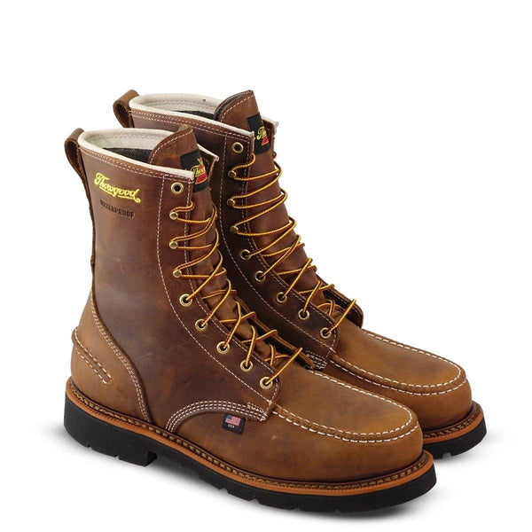 pair of mens brown logger boot with black soles white stitching and yellow thorogood logo, side front view