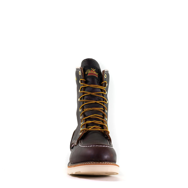 front view of dark brown high top moccasin style boot with yellow/brown laces and thorogood logo on top of tongue.