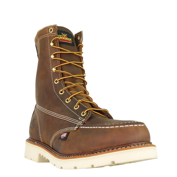 mens rugged brown logger boot with white interior, sticthing, and sole. Black thorogood logo stamped on heel with gold/red laces. front corner view