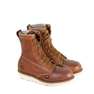 Pair of mens brown logger boot with white interior, sticthing, and sole. Black thorogood logo stamped on heel with gold/brown laces.
