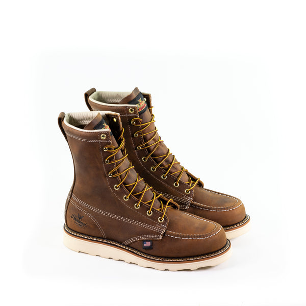 pair of mens brown logger boots with white sole and stitching and yellow/brown laces