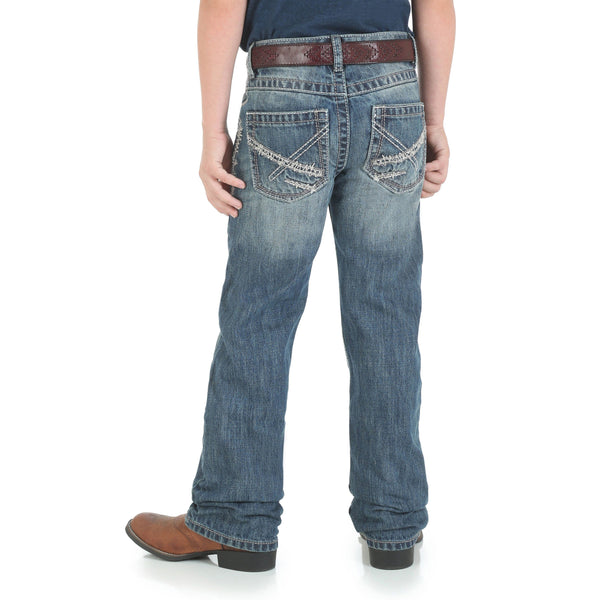 boy in navy shirt and big brown belt with faded jeans back view