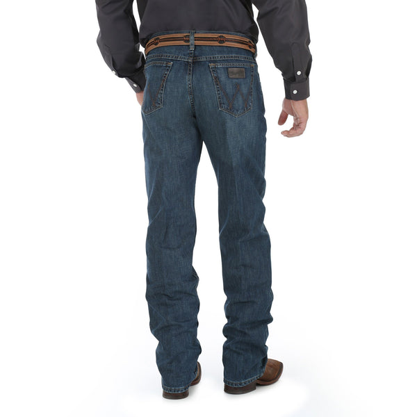 Man in Smoke Colored Solid Buttonup with big belt in dark blue jeans back view