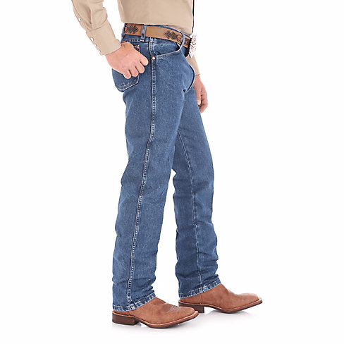 Man in Tan Button up Wearing large belt and Mute blue jeans side angle