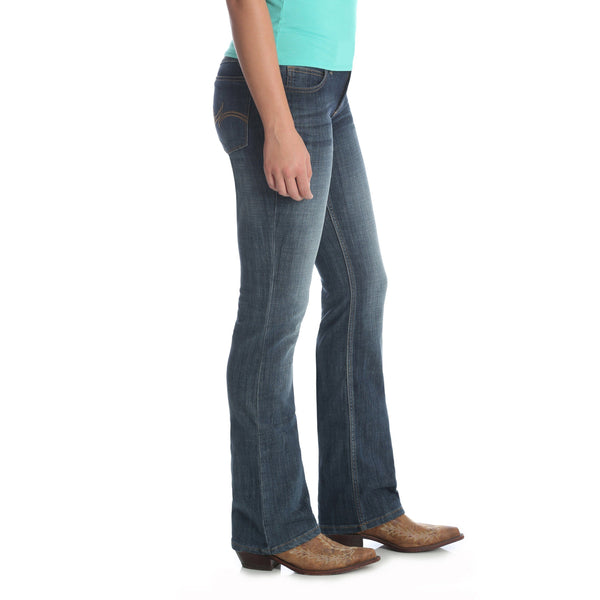 woman in teal wearing faded blue jeans side view