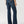 Load image into Gallery viewer, back view of women wearing wide leg blue jeans with tan boots and hands at her side
