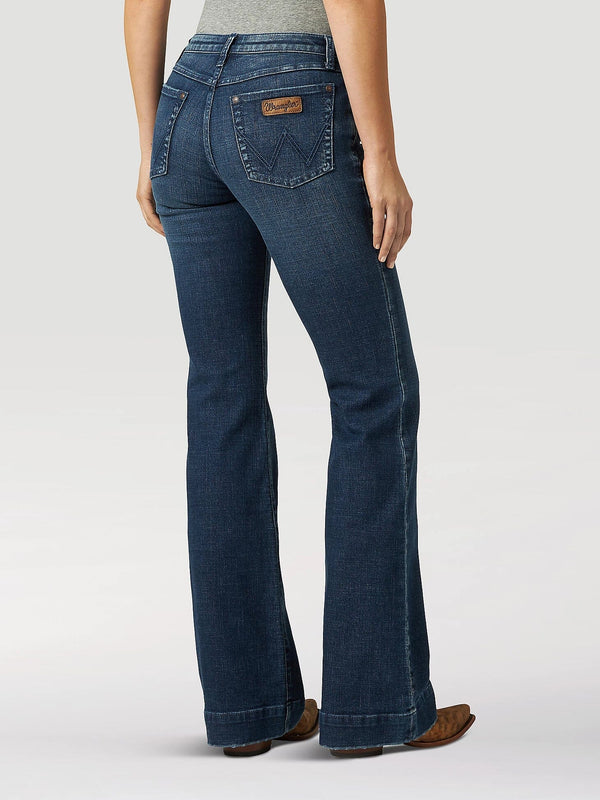 back view of women wearing wide leg blue jeans with tan boots and hands at her side